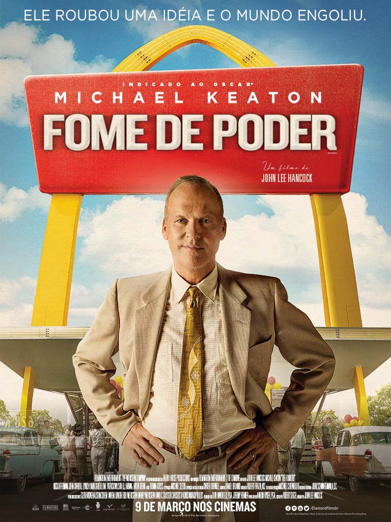 Ator principal do filme Fome de Poder, de terno, com as mãos na cintura, em frente a uma loja de fast food.