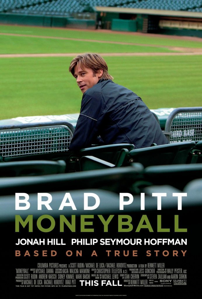 Cartaz do filme Moneyball. Ator Brad Pitt sentado em uma cadeira no jogo de baseball olhado para o lado.