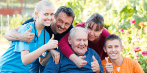 Família feliz e uma médica ao lado fazendo sinal de positivo com a mão.