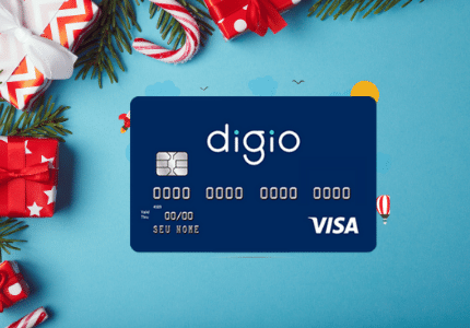 Cartão de Crédito Digio bandeira Visa e no fundo alguns enfeites de natal.