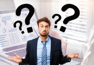 Homem de terno com várias interrogações, representando as dúvidas ao investir.