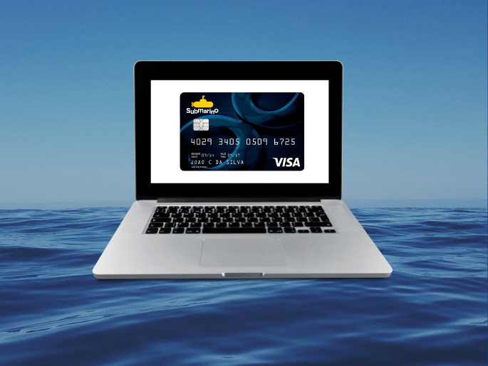 Laptop submerso no oceano, com cartão de crédito Submarino na tela.