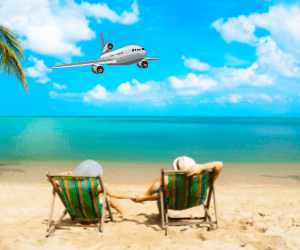 Casal passando férias na praia, deitados em cadeiras de praia na areia e observando o mar e um avião no céu.
