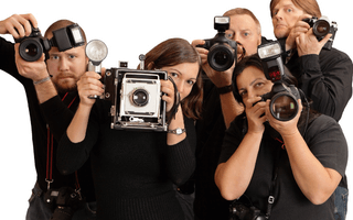 Cinco fotógrafos de roupas pretas.