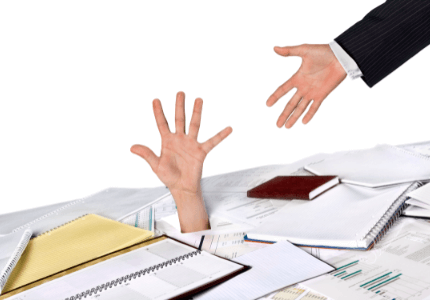 Uma mão ajudando a outra mão a sair do buraco em uma mesa cheia de papéis de dívidas.