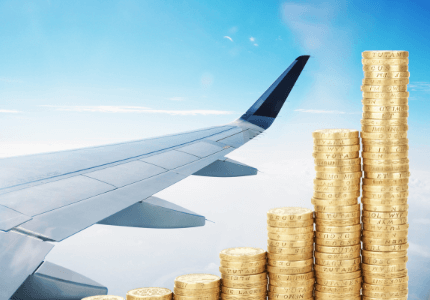 Asa de avião com moedas representando renda extra com pontos e milhas.