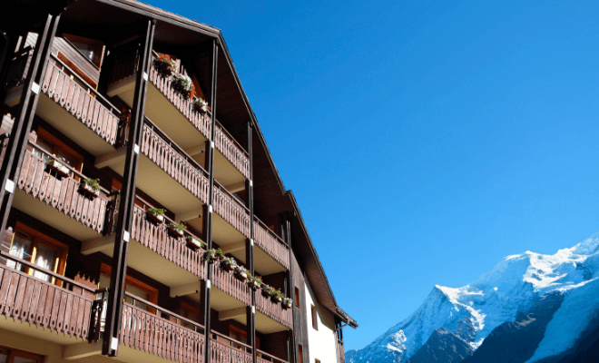 Hotel alugado barato na Europa com montanhas ao fundo.