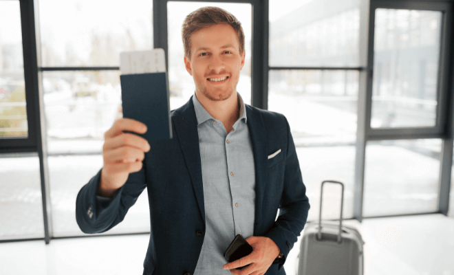 Homem de mala, celular e passaporte na mão, ciente da validade do passaporte brasileiro.
