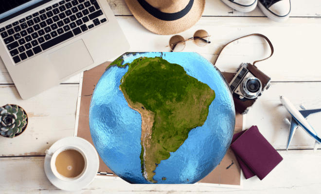 Itens para viagem e globo mostrando a América do Sul, local de viagens internacionais sem passaporte para brasileiros.