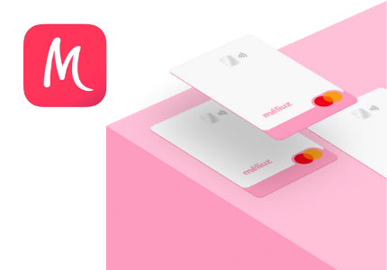 Cartão de Crédito Méliuz suspenso sobre o mesmo cartão em cima de uma caixa rosa.