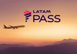 Avião voando no por do sol em uma paisagem com montanhas. Acima logomarca do programa de fidelidade Latam pass.
