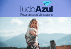 Mulher apontando com o dedo para frente em um cenário de montanhas. Acima logomarca do programa de vantagens Tudo Azul.