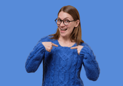 Mulher de óculos e blusa de frio azul apontando para si mesma como uma pessoa que pode fazer o saque emergencial do FGTS.