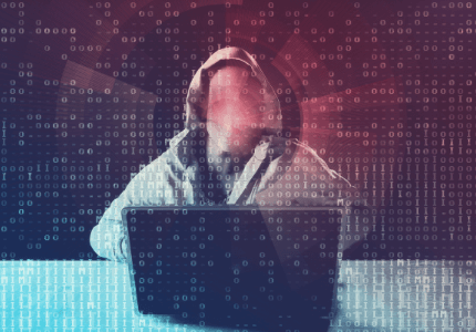 Criminoso de capuz, usando o laptop, representando o golpe do falso funcionário bancário.