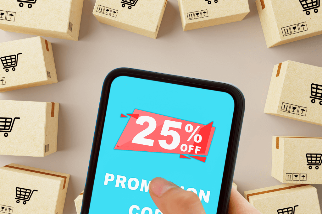 Celular com um desconto de 25% representando um cupom ifood aberto em tela, com caixas de compras ao fundo.