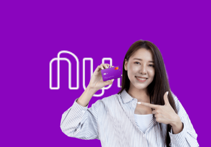 Mulher segurando o cartão de crédito Nubank, feliz por ter sido incluída nas mais de 580 mil pessoas que receberam o aumento do limite, com símbolo do Nubank ao fundo.