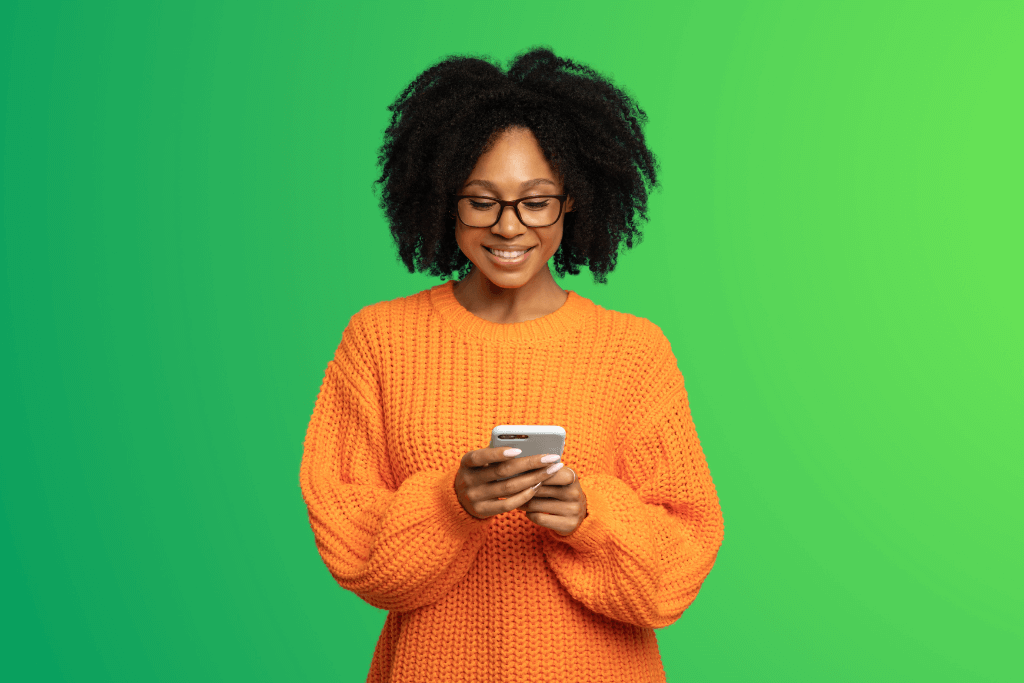 Mulher animada simulando o empréstimo Simplic pelo celular.