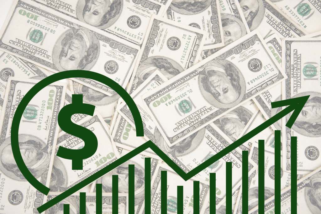 Gráfico crescente com símbolo do dólar ao lado, com notas de  cem dólares de fundo.