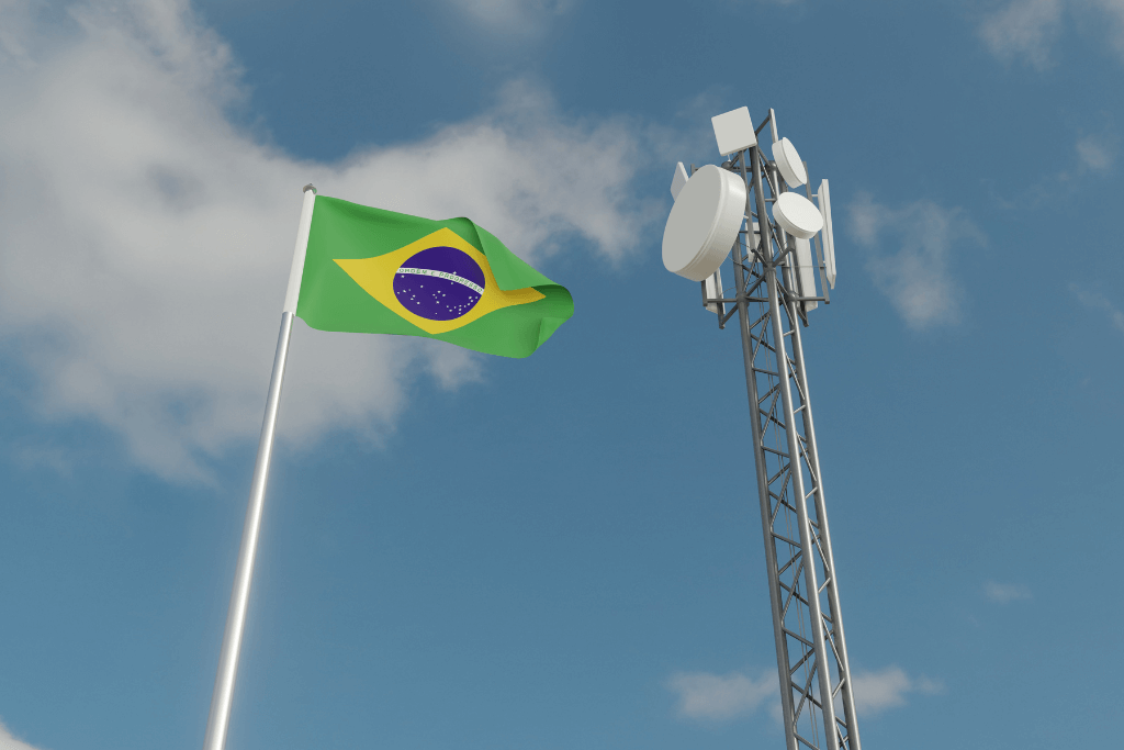 Bandeira brasileira ao lado de uma antena de transmissão de internet,.