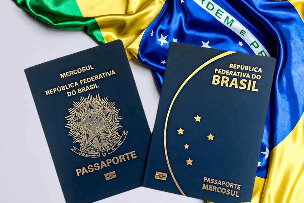 Novo passaporte, frente e verso, ao lado da bandeira brasileira dobrada.