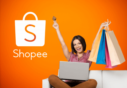Mulher animada com computador no colo e compras nas mãos, indicando que fez compras online na Shopee.