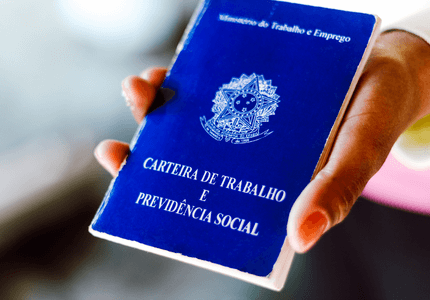 Pessoa segurando uma carteira nacional de trabalho.