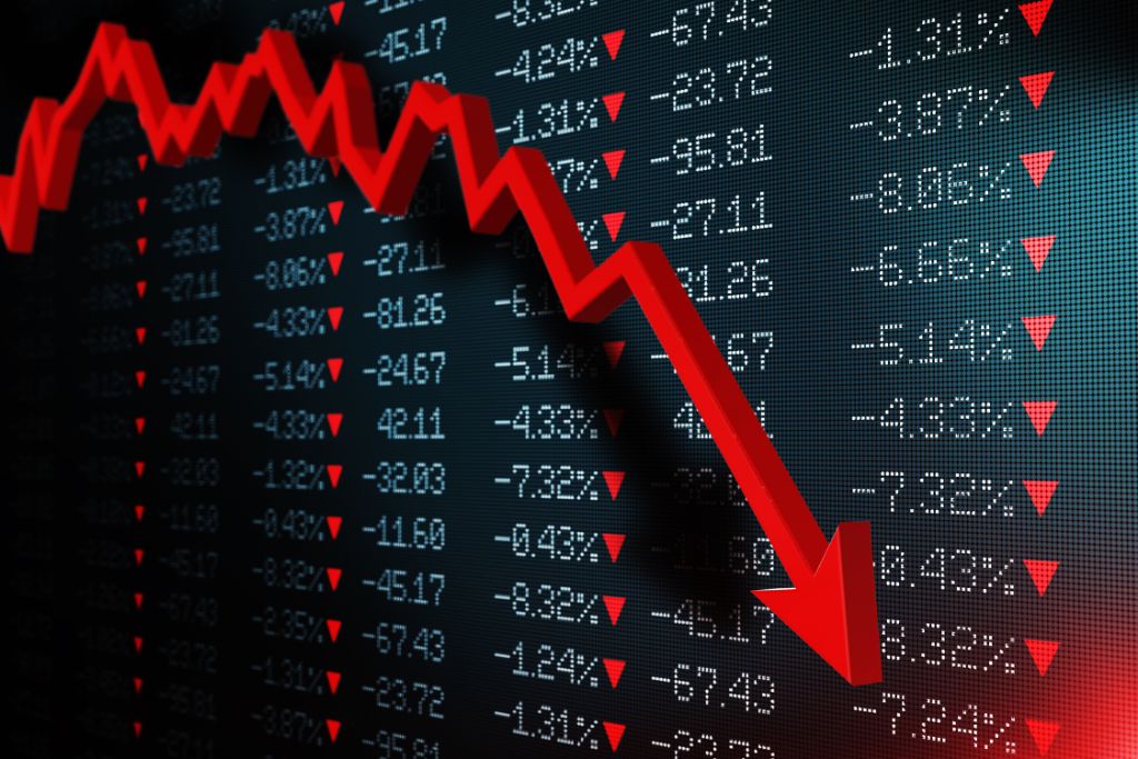 Painel da bolsa de valores com uma seta vermelha para baixo.