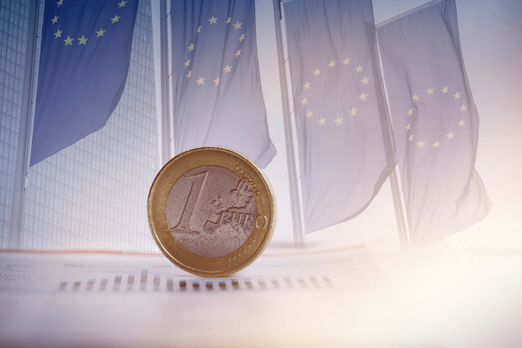 Moeda de Euro a frete de quatro bandeiras da União Europeia.