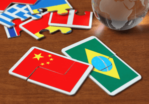 Cartões com imagens das bandeiras do Brasil, da China e de outros países em cima de uma mesa.