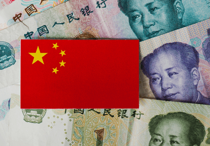 Cartão com a bandeira da china em cima de cédulas da moeda oficial do país.