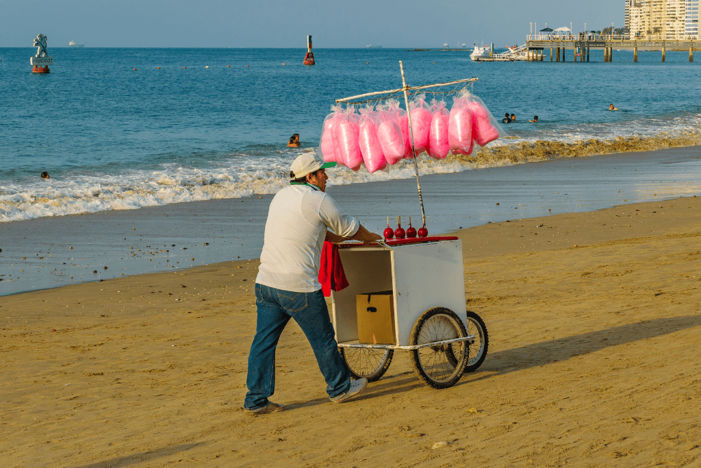 Vendedor ambulante vendendo algodão doce na praia.