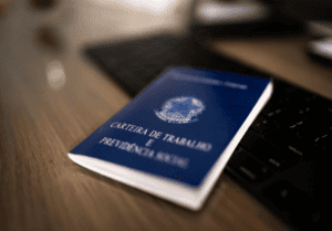 Carteira de trabalho em cima de um teclado de computador.