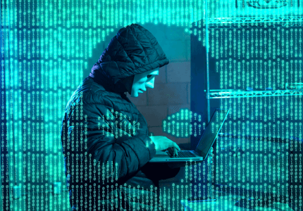 Hacker mascarado mexendo no laptop e vários números de código binário envolvendo-o.