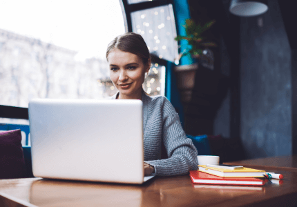 Mulher buscando informações em um laptop.