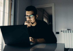 Homem usando o laptop para solicitar o cartão de crédito Bradesco Visa Infinite.