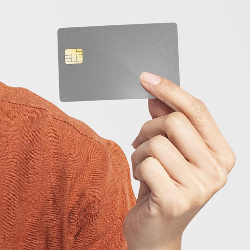 Mão segurando um cartão de crédito que gera milhas aéreas.