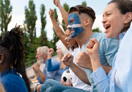 Aficionados celebrando en un estadio durante el Mundial de Fútbol 2026, representando el sueño de viajar y financiar una experiencia futbolística internacional.