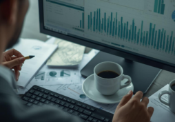 Pessoa analisando gráficos financeiros no computador, representando planejamento financeiro e decisão de investimentos