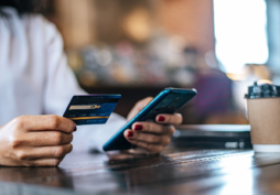 Pessoa segurando cartão e celular com saldo indisponível