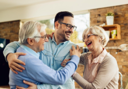 Família reunida e sorrindo, representando proteção financeira e benefício do seguro de vida para os beneficiários